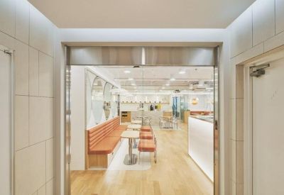 Main entrance hallway featuring a glass sliding door and light wood flooring.