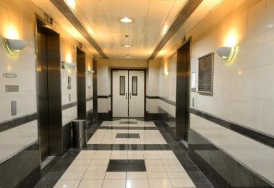 Symmetrical elevator lobby with marble floors and warm wall sconces.