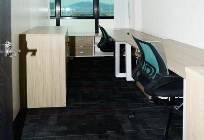 Private office space with wooden desks and windows overlooking city hills.