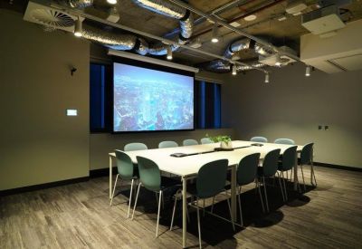 High-tech meeting room with a large projector screen showing a city aerial view.