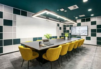 Large meeting room with yellow velvet chairs, a dark table, and a checkered wall design.