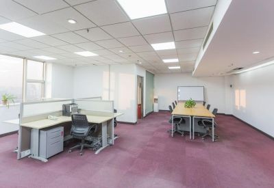 Spacious open-plan workspace with purple carpeting, desks, and a separate meeting table.