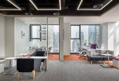 Modern office workspace with ergonomic chairs, breakout seating, and city views.
