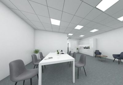 Large white conference table in a minimalist meeting room with grey chairs.