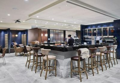 Spacious communal lounge and café area with a black marble bar and stylish stools.