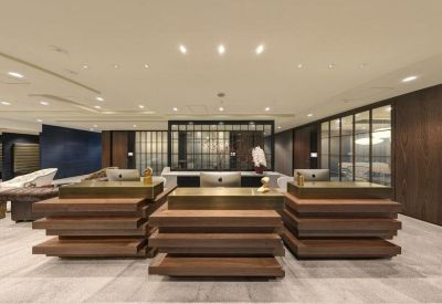 Sleek modern reception area with tiered wooden desks and warm lighting.