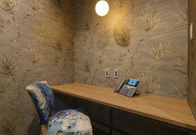 Quiet individual workspace with a floral accent wall and a patterned armchair.