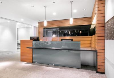 Reception area with a sleek grey front desk and warm horizontal wood panelling.