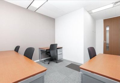 Four-person office suite with individual desks and grey carpeting.