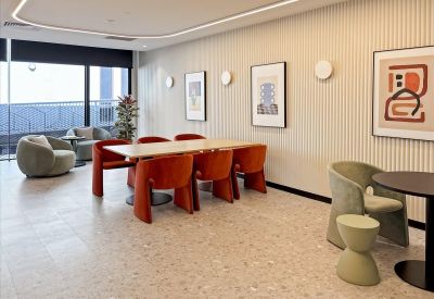 Modern communal breakout space at 2-3 Greenhill Road, Wayville, featuring orange chairs and soft lighting.