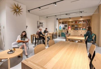 Quiet breakout area with a variety of wooden tables and built-in shelving.
