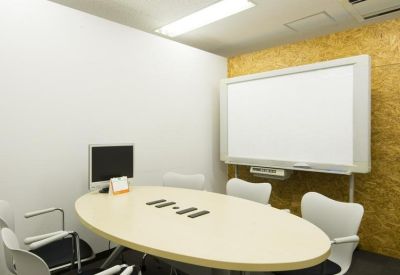 Modern meeting room with an oval table, whiteboard, and wood-textured accent wall.
