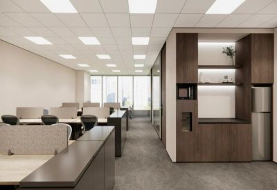 Bright open-plan office with multiple workstations and a modern wooden pantry unit.