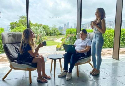 Bright breakout area with floor-to-ceiling windows and views of the city greenery.