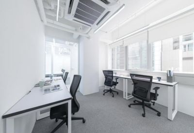Bright workspace featuring white desks and black ergonomic chairs.