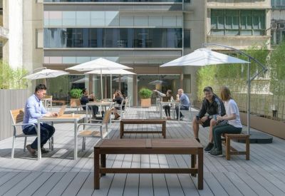 Sunny outdoor terrace with wooden decking and white patio umbrellas.