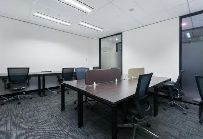 Professional workspace with clustered desks and glass-walled private offices.