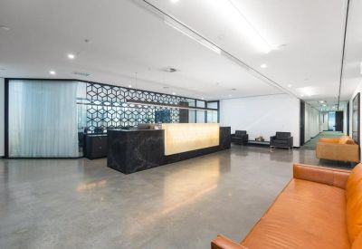 Sleek office reception area with a minimalist black and backlit front desk.