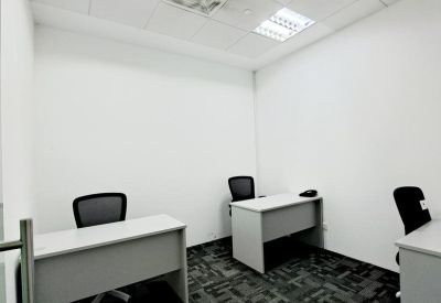 Private two-person office with grey desks and black ergonomic chairs.