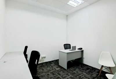 Internal office suite with a corner desk and white guest chairs.