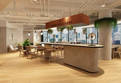 Bright communal lounge with a large island counter, hanging plants, and city views.