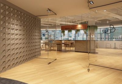 Modern glass entrance with a geometric stone feature wall and wooden flooring.