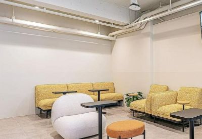 Modern lounge area with yellow modular sofas and a unique white circular armchair.