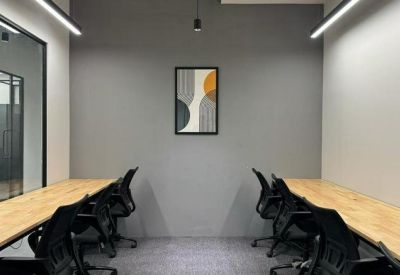 Workspace with long wooden desks and black ergonomic chairs at Pride Icon.