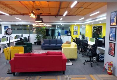 Bright coworking area with colorful sofas in red, yellow, and blue.