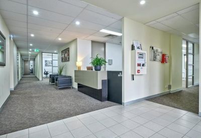 Spacious reception area with grey front desk and long corridor view.