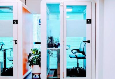 Sleek private phone booths for quiet calls with glass doors and black accents.