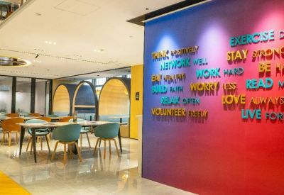 Vibrant communal wall featuring colorful motivational text in a spacious lounge area.