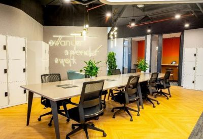 Professional meeting room with a long table, ergonomic black chairs, and white storage lockers.