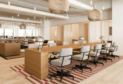 Modern open-plan office with a long wooden desk, ergonomic chairs, and unique spherical pendant lights.