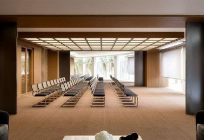 Bright auditorium style meeting space with rows of seating and a decorative light wood ceiling.