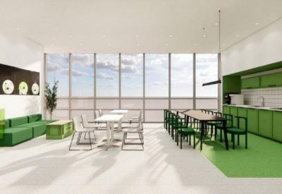 Spacious open-plan coworking area with green accents and large floor-to-ceiling windows.