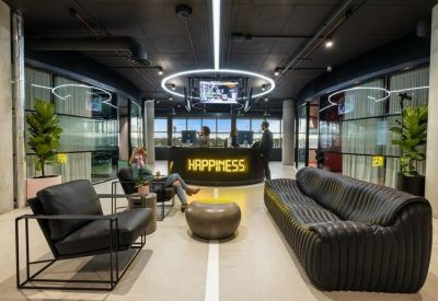 Contemporary reception desk with a neon Happiness sign and lounge seating.