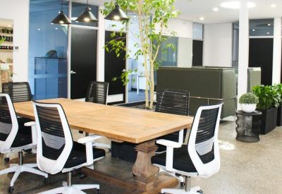 Professional meeting room with a large timber table, ergonomic chairs, and natural light.