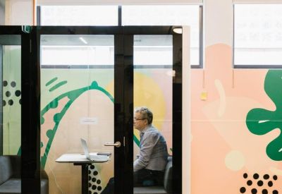 Private phone booth or focused workspace with colorful illustrative wall art.