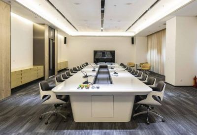 Sleek conference room featuring a long white table and modern ergonomic chairs.