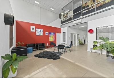 Spacious communal lounge with a red feature wall, modern seating, and vibrant artwork.