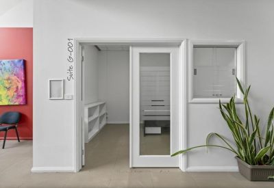 Glass-paneled office entrance marked Suite G-001 with views into a workspace.