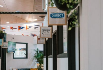 Interior corridor view showing glass-walled office suites and hanging greenery.