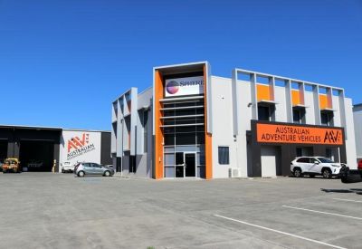 Open-plan office with wooden desks and office chairs.