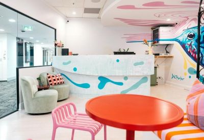Bright reception area featuring a patterned front desk and colorful hummingbird wall art.