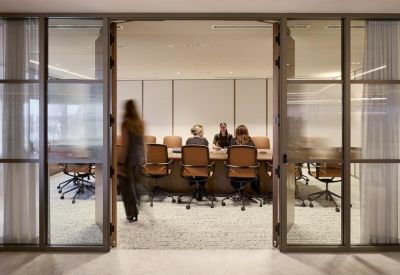 Modern glass-walled boardroom with professional seating and white walls.