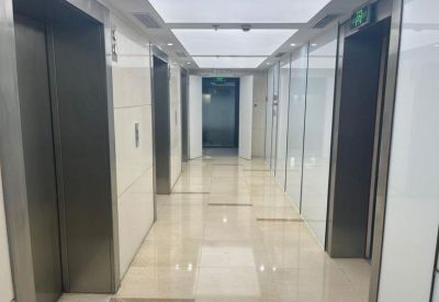 Brightly lit elevator bank with white wall panels and polished floors.