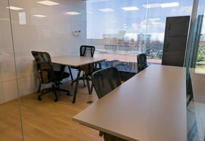 Internal four-person office suite enclosed in glass walls.
