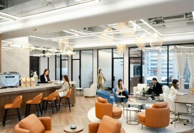 Contemporary open-plan workspace with multiple seating arrangements and warm overhead lighting.