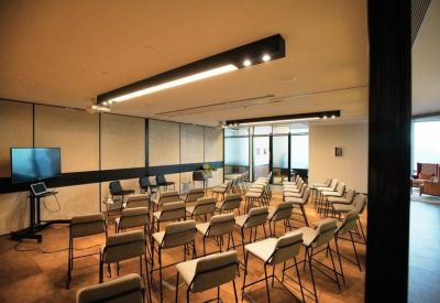 Large meeting room arranged in a theater style with rows of grey chairs.
